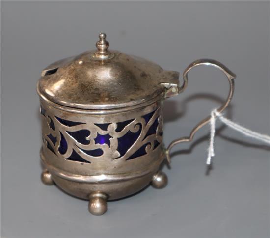 An Edwardian small pierced silver mustard pot, with blue glass liner, James Deakin & Sons, Sheffield, 1905.